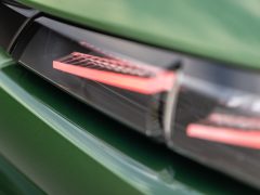 Close-up van het achterlicht van een groene Peugeot 308, met gedeeltelijke reflecties.