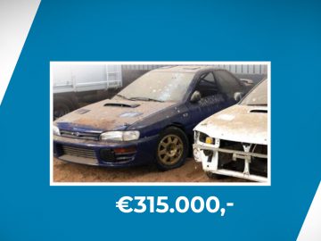 Een afbeelding van een stoffige blauwe Subaru Impreza geparkeerd naast een gedeeltelijk gedemonteerde witte auto, tentoongesteld met een prijs van € 315.000.