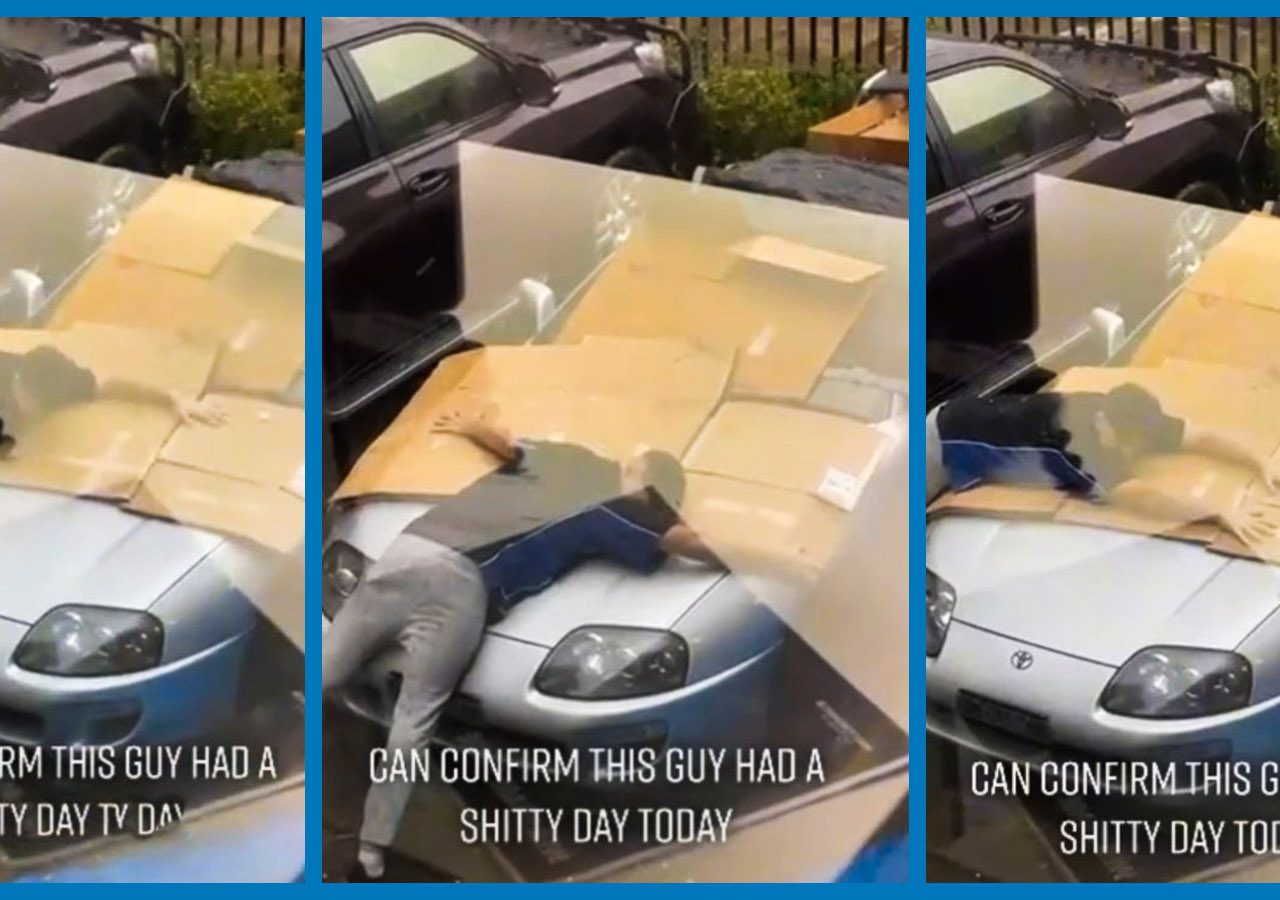 Een man ligt met zijn gezicht naar beneden op een Toyota Supra met kartonnen dozen om hem heen, en op de tekst staat: "KAN BEVESTIGEN DAT DEZE MAN VANDAAG EEN SHITTY DAY HAD.
