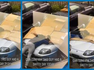 Een man ligt met zijn gezicht naar beneden op een Toyota Supra met kartonnen dozen om hem heen, en op de tekst staat: "KAN BEVESTIGEN DAT DEZE MAN VANDAAG EEN SHITTY DAY HAD.