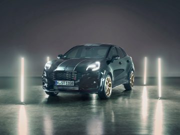 In een studiosetting wordt een donkergekleurde Ford Puma ST Gold Edition met verlichte verticale lampen eromheen tentoongesteld. De auto is voorzien van een kentekenplaat vooraan met de tekst "K-ST 1108".