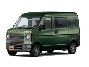 Een groene, vintage-stijl Suzuki-bestelwagen met een vierkant ontwerp en een chromen grille. Het voertuig is voorzien van grote ramen en schuifdeuren aan de zijkanten.