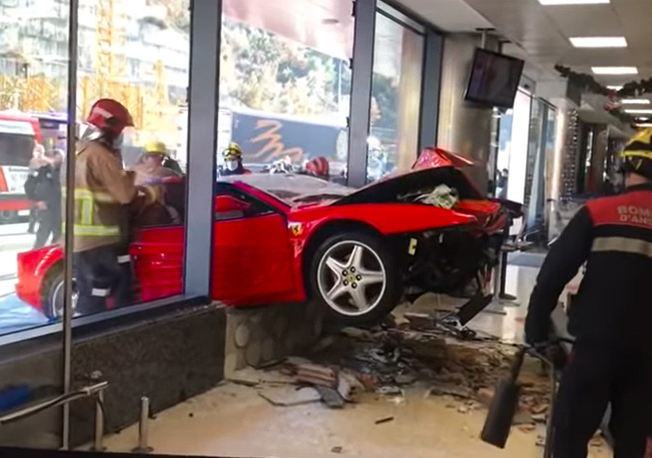 Een rode Ferrari botste tegen het glazen raam van een gebouw. Hulpverleners in uniform doen onderzoek ter plaatse. Er ligt vuil op de vloer in het gebouw.