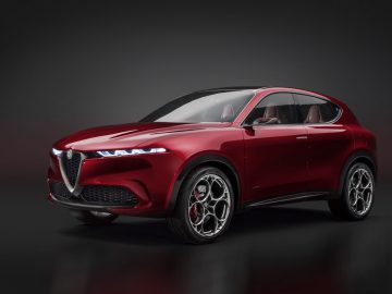 Een rode Alfa Romeo Tonale SUV met een strak ontwerp, voorzien van LED-koplampen, lichtmetalen velgen en een prominente grille, afgebeeld tegen een donkere achtergrond.