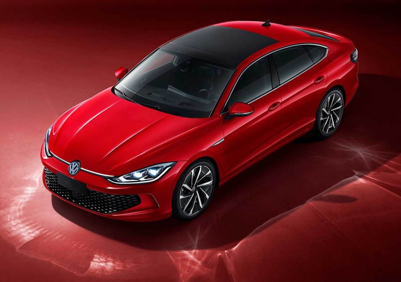 Een rode Volkswagen sedan staat geparkeerd op een levendig rood oppervlak, waardoor de strakke lijnen en zwartgetinte ramen goed tot hun recht komen.
