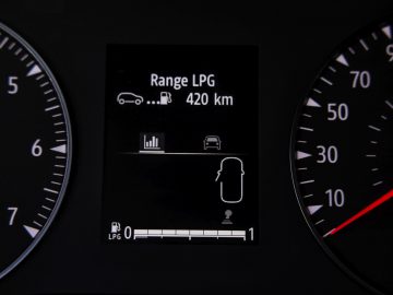 Autodashboarddisplay met de LPG-brandstofactieradius tot 420 km, omringd door snelheids- en toerentellermeters, zoals te zien in de laatste Dacia Jogger-recensie.