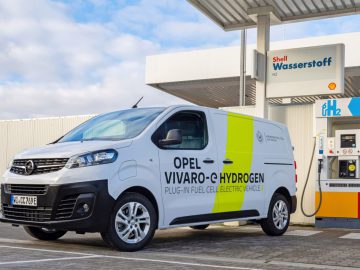 Bij een waterstoftankstation van Shell staat een witte Opel Vivaro-e Waterstofbusje, een echte waterstofauto, geparkeerd met op de zijkant trots ‘Plug-in Fuel Cell Electric Vehicle’ afgebeeld.