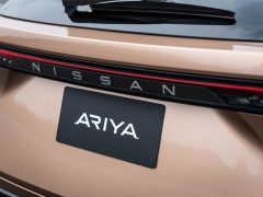 Close-up van de achterkant van de Nissan Ariya, een 100% elektrische crossover, met het Nissan-logo en het Ariya-naamplaatje op de kofferbak.