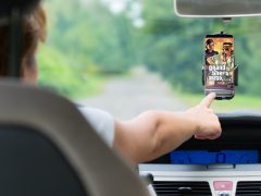 Een persoon raakt een smartphone aan die op de voorruit van een auto is gemonteerd en waarop de cover van het spel