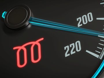 Close-up van de meter op het dashboard van een auto die 220 weergeeft met een verlicht rood waarschuwingssymbool dat lijkt op een veer of spoel, wat wijst op een mogelijk probleem met de Gloeibougie.