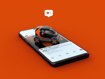 Een miniatuurmodelauto met oranje en zwarte kleuren wordt op een smartphone geplaatst met daarop een sociale media-app. Het mobiliseren van de aandacht, een meldingsballon met een hartpictogram en de nummer één zweeft erboven.