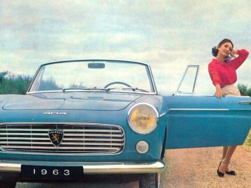 Een vrouw in een rode top en witte rok staat bij een blauwe Peugeot 404 cabriolet uit 1963 met het bestuurdersportier open, glimlachend terwijl ze een telefoon tegen haar oor houdt, wat de tijdloze charme van de klassieke auto belichaamt.