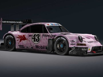 Een roze raceauto met nummer 43 op de zijkant, met verschillende sponsorlogo's, waaronder Mobil1 en Toyo Tires, uitgerust met een grote achtervleugel en aerodynamische carrosserieaanpassingen geïnspireerd op de iconische stijl van Ken Block.