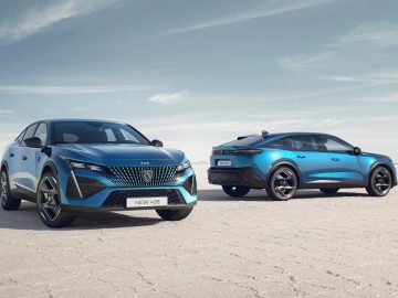 Twee blauwe moderne auto's, waaronder een strakke Peugeot 408, staan geparkeerd in een uitgestrekt, droog, woestijnachtig landschap onder een heldere hemel. De ene auto kijkt naar voren, terwijl de andere van achteren wordt getoond.