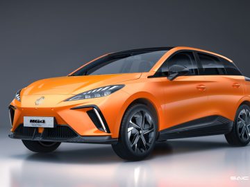 Een oranje MG4 elektrische auto wordt tentoongesteld in een studioomgeving en toont het strakke ontwerp met hoekige koplampen, zwarte sieraccenten en futuristische lichtmetalen velgen. De MG4 Electric valt op door zijn moderne esthetische en geavanceerde kenmerken.