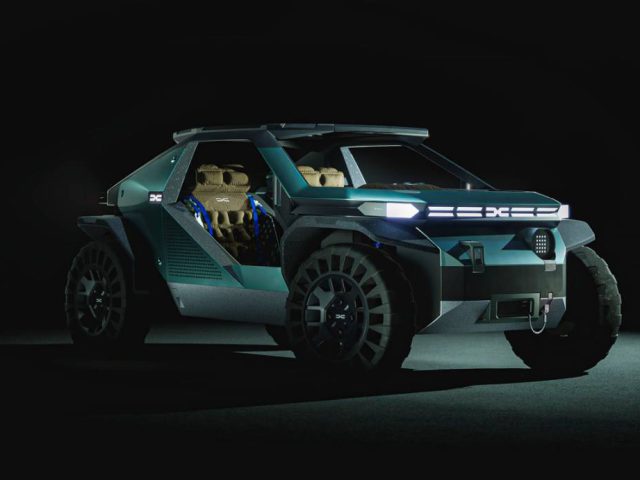 Een futuristische Dacia-terreinwagen met grote banden, verlichte koplampen en een open deurontwerp wordt tentoongesteld in een donkere omgeving.