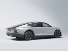Een zilveren Lightyear elektrische auto met een strak ontwerp op een witte achtergrond, gezien vanuit de achterste hoek.