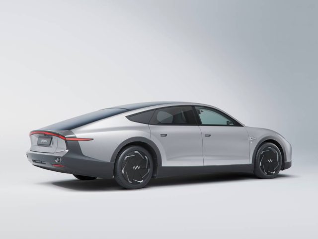 Een zilveren Lightyear elektrische auto met een strak ontwerp op een witte achtergrond, gezien vanuit de achterste hoek.