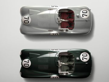 Twee klassieke raceauto's van bovenaf gezien, een zilveren en een donkergroene Jaguar C-Type, beide genummerd 70 op de motorkap en deuren, met open cockpits en vintage design.