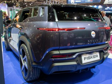 Op de Autosalon Parijs 2022 wordt een grijze elektrische SUV van Fisker Ocean tentoongesteld, met de achterlichten en het merklogo aan de achterkant.