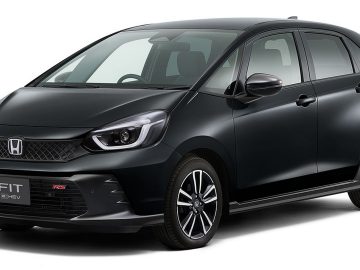 Een zwarte Honda Fit e:HEV RS hatchback, in sommige markten ook wel de Honda Jazz RS genoemd, staat geparkeerd en heeft een modern ontwerp met een grille, koplampen en lichtmetalen velgen.