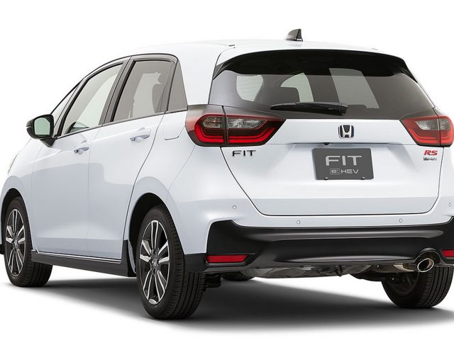 Een witte Honda Fit RS hybride auto, in sommige regio's ook bekend als de Honda Jazz RS, linksachter gezien, met de achterlichten, het achterembleem en een deel van de rechterkant.