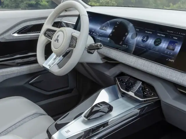 Interieur van de Mitsubishi XFC Concept-auto met een strak dashboard, groot digitaal display, stuurwiel en middenconsole met futuristische designelementen.