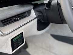 Close-up van het interieur van een Stinger-auto met een digitaal display ingebed in het dashboard, het stuur en een deel van de middenconsole.