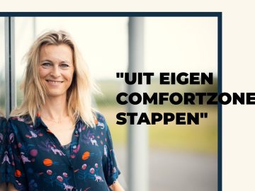 Een persoon met blond haar, gekleed in een donker shirt met kleurrijke patronen, staat naast een reflecterend oppervlak. Ernaast staat de tekst "UIT EIGEN COMFORTZONE STAPPEN", mogelijk geïnspireerd door Amber Donkervoort.