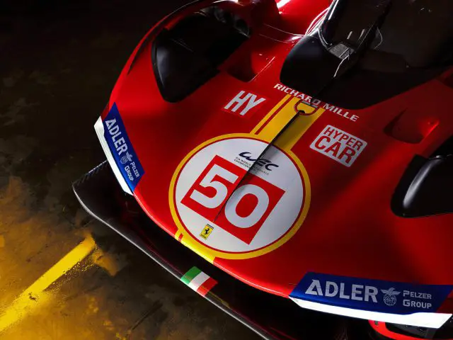 Close-up van de voorkant van een Ferrari 499P-raceauto met het nummer 50, voorzien van verschillende sponsorlogo's en strakke aerodynamische componenten.