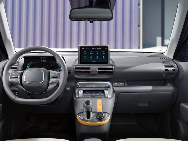 Binnenaanzicht van een Hyundai Casper-dashboard met een modern aanraakscherm, digitaal instrumentenpaneel, stuurwiel en bedieningselementen op de middenconsole.