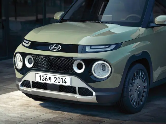 Een groene Hyundai Casper SUV geparkeerd op een geplaveid pad, met een witte kentekenplaat aan de voorkant met het nummer "136# 2014" en ronde koplampen.