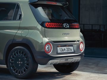 Van de achterkant is een groene Hyundai Casper mini-SUV te zien, met een uniek ontwerp met twee ronde achterlichten en een kentekenplaat met nummer 138 van 2014. Deze specifieke Hyundai Casper biedt zowel stijl als functionaliteit in zijn compacte vorm.