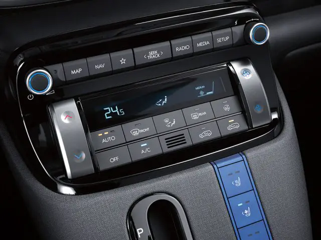 Close-up van het infotainment- en klimaatbedieningspaneel van een Hyundai Casper met knoppen voor navigatie, radio, media, setup en temperatuuraanpassing. Op het display staat een temperatuurinstelling van 24,5 graden Celsius.