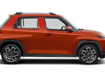 Zijaanzicht van een oranje Hyundai Casper compacte SUV met zwarte bekleding en een plat dak, tegen een witte achtergrond.