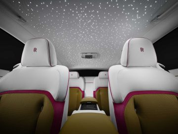 Het interieur van de Rolls-Royce Spectre is voorzien van witte stoelen met roze accenten, lichtbruine inzetstukken en een boeiend sterrenhemeleffect op het plafond.