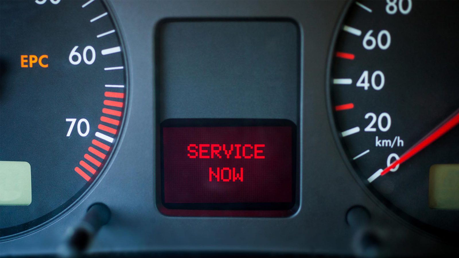 Dashboard van een voertuig met een rood bericht "SERVICE NOW" met een verlicht EPC-lampje en snelheids- en toerentellermeters.