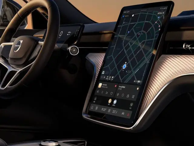 Interieur van een Volvo EX90 met het stuur en een groot verticaal touchscreen met een navigatiekaart.