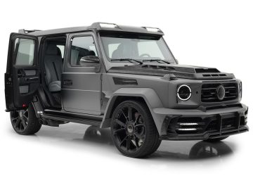 Een matzwarte luxe SUV van Mansory G-Klasse met de achterpassagiersdeur open, met een donker lederen interieur en op maat gemaakte zwarte velgen op een witte achtergrond.