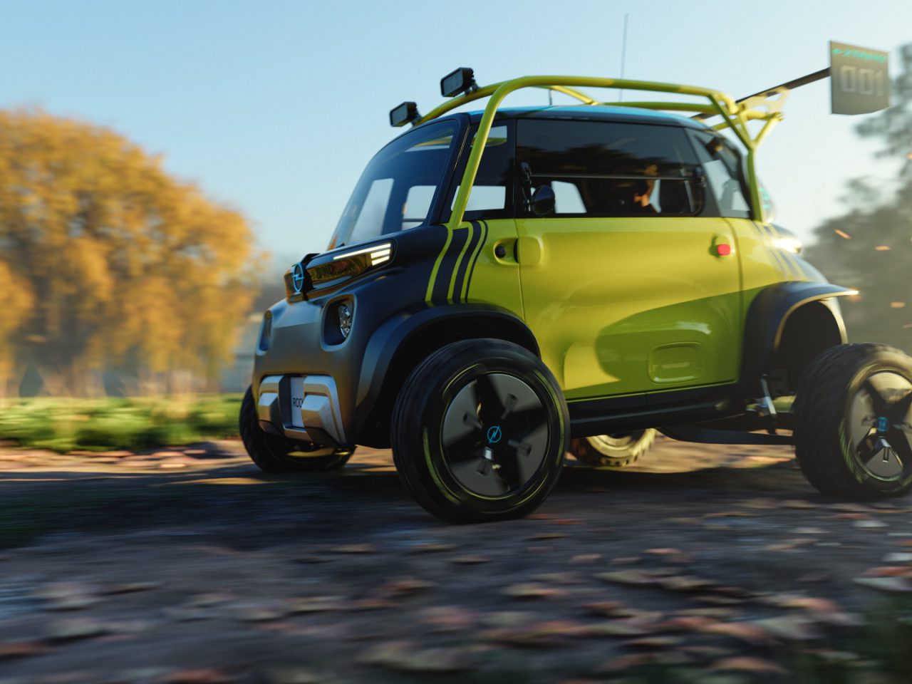 Een kleine, groene Opel Rocks e-xtreme met grote banden rijdt over een onverharde weg in een schilderachtige buitenomgeving met bomen op de achtergrond.