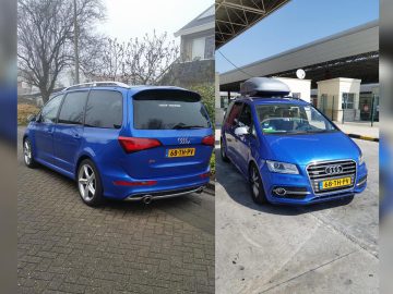 Twee blauwe Audi-voertuigen, beide met identieke kentekenplaten, staan apart geparkeerd. De eerste Audi staat in de buurt van gebouwen, terwijl de tweede, uitgerust met een dakkoffer, handig bij een tankstation is geplaatst.