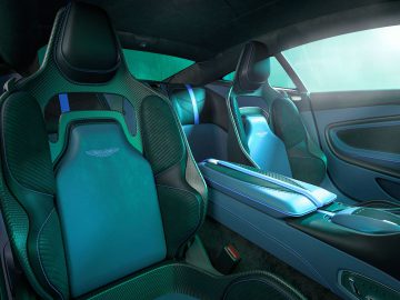 Interieur van de Aston Martin DBS 770 Ultimate met luxe zwarte en blauwe sportstoelen, koolstofvezelaccenten en een strakke middenconsole.