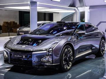 Een moderne, strakke Chinese elektrische auto, tentoongesteld onder felle showroomverlichting, met een gestroomlijnd ontwerp met scherpe lijnen en futuristische details.