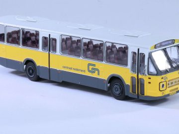 Een schaalmodel van een geel-witte bus van Centraal Nederland, gezien vanuit een driekwarthoek, met gedetailleerde ramen, wielen en logo's op de zijkant. Dit uitzonderlijke stuk werd bekroond met "Miniatuurauto van het Jaar.
