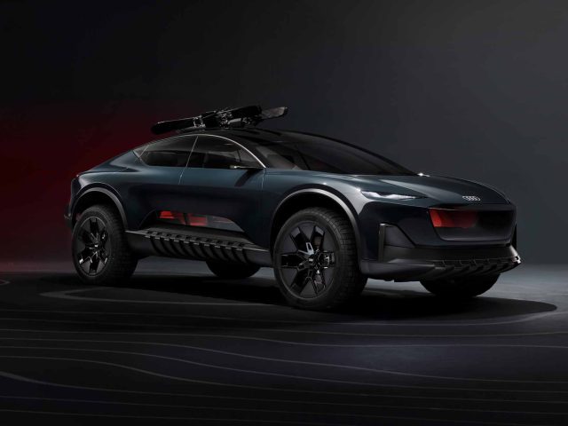 Tegen een donkere achtergrond wordt een slanke, donkergekleurde Audi Activesphere Concept SUV met dakuitrusting getoond. Het voertuig heeft grote banden, een futuristisch ontwerp en opvallende rondingen.