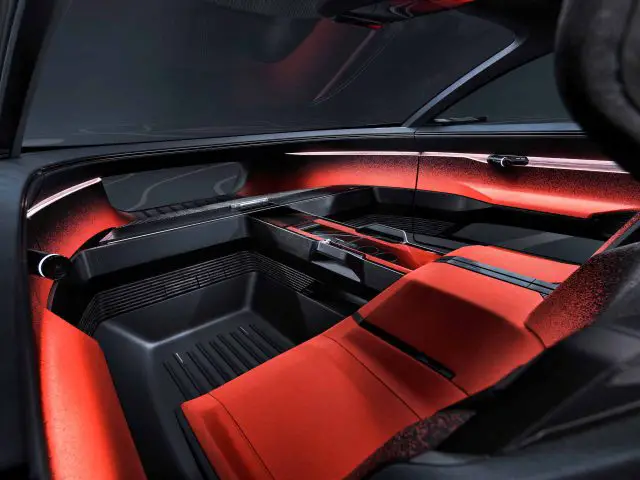 Futuristisch auto-interieur met rode en zwarte stoelen, een minimalistisch dashboard en verlichte accenten geïnspireerd op het Audi Activesphere Concept.
