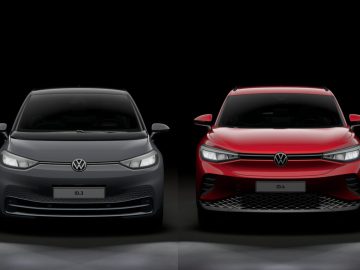 Vooraanzicht van twee elektrische voertuigen van Volkswagen: links een grijze ID.3 en rechts een opvallende rode Volkswagen ID.4, beide tegen een donkere achtergrond.
