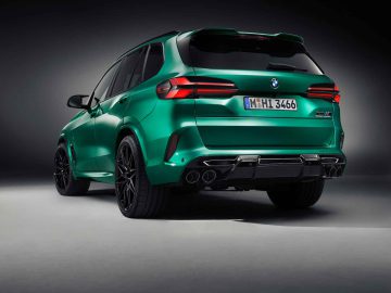 Achteraanzicht van een groene BMW X5 M Competition SUV, met de achterlichten, achterbumper, zwarte velgen, viervoudige uitlaatpijpen en kentekenplaat "M HI 3466".