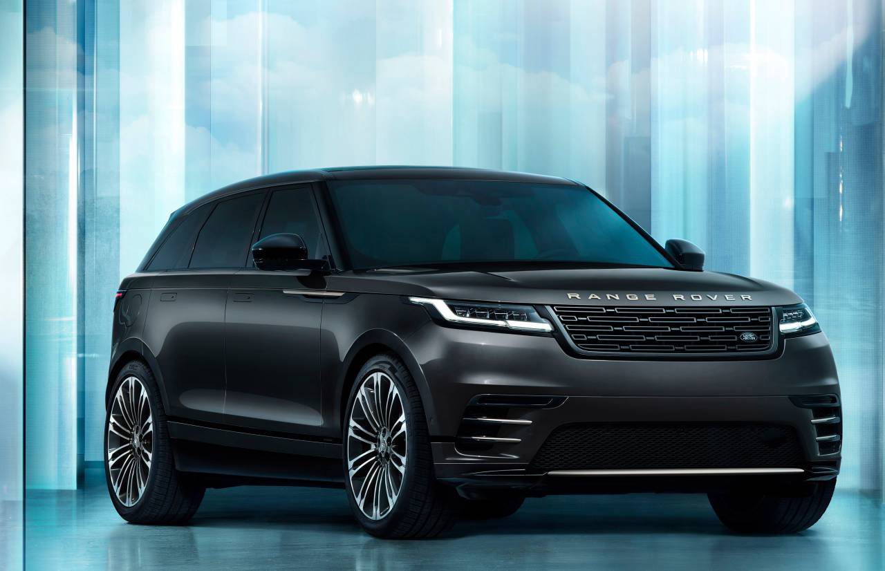 Een zwarte Range Rover Velar SUV geparkeerd voor een futuristische, lichtblauwe achtergrond met reflecterende oppervlakken.