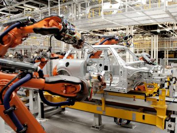 Geautomatiseerde robotarmen assembleren een autoframe in de ultramoderne autofabriek van VDL Nedcar.